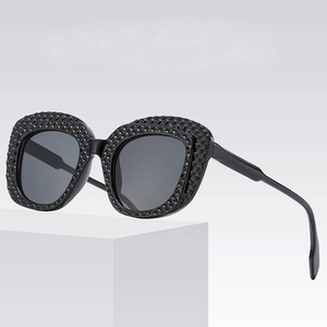 Chic black textured oval sunglasses with studded frame and dark lenses for women