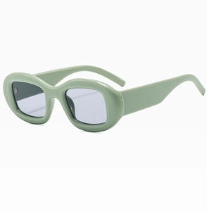 Détail de lunettes de soleil rétro ovales vert clair avec monture épaisse à 45 degrés