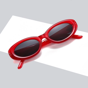 Vintage red oval cat eye sunglasses with dark lenses for UV protection on a white display