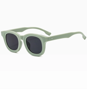 Detailed view of sage green thick frame sunglasses with dark lenses and metal studs