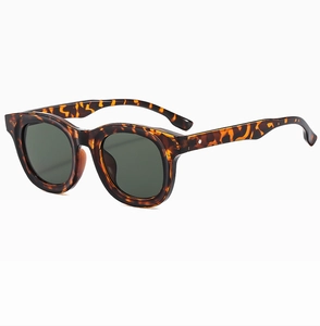 Close-up of tortoise shell thick frame oval sunglasses with dark green lenses