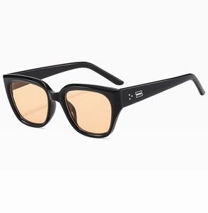 Detail of square black frame sunglasses with orange lenses and silver metallic stud accents