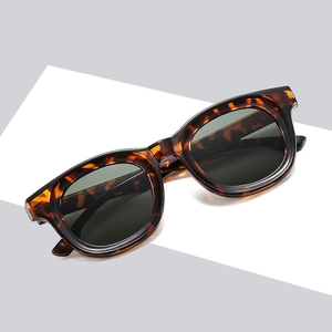 Retro tortoise shell sunglasses with large dark lenses on minimalist display