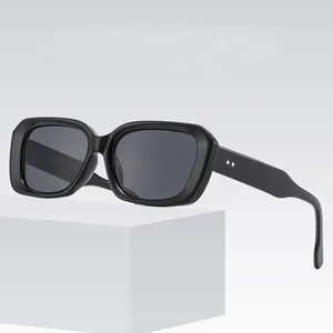 Retro square black sunglasses with diamond rivets displayed on a white minimalist stand