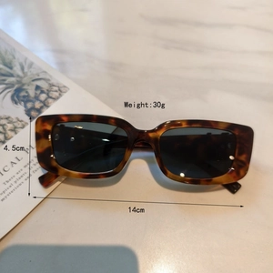Flat lay of tortoiseshell rectangle sunglasses with 30g weight and size specifications