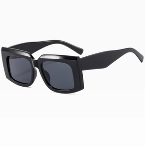 Detail of chunky black square frame sunglasses with thick temples and dark gray lenses