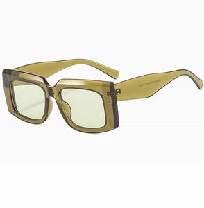 Detail shot of vintage rectangular olive green sunglasses showing thick transparent frame