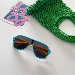 Détail de lunettes de soleil aviateur bleues et jaunes pour enfants sur fond vert