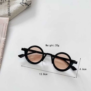 Detail view of steampunk kids' round sunglasses with light brown lenses and black frame