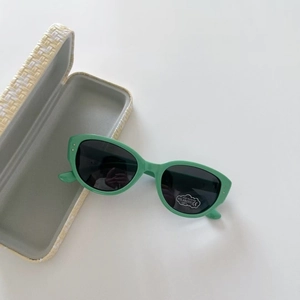Gros plan sur lunettes de soleil vert menthe polarisées avec étiquette UV400 et étui