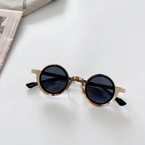 Detail of kids steampunk sunglasses with gold metal round frame and dark lenses