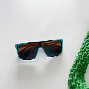 Détail de lunettes de soleil sport pour enfants avec monture sarcelle et verres orange