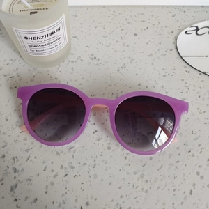 Détail des lunettes de soleil rondes violettes pour enfants avec verres dégradés