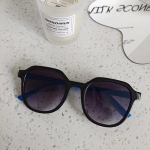 Detail of stylish square sunglasses with gradient lenses on a grey granite surface