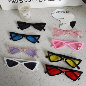 Retro triangle cat eye sunglasses for kids in eight colors on a grey stone background