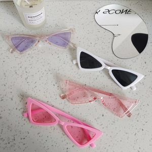 Retro triangle kids sunglasses for boys and girls in four stylish colors displayed on stone