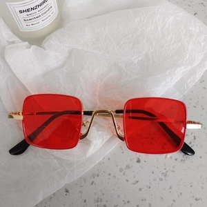 Close-up of kids vintage round sunglasses with gold metal frame and red tinted lenses