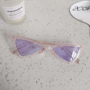 Detail shot of vintage triangle cat-eye sunglasses with pink frame and purple lenses
