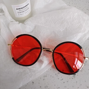 Detail of red transparent lenses with retro gold metal and black frames for kids