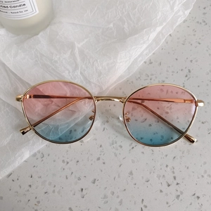 Détail des verres dégradés rose et bleu sur lunettes de soleil enfant dorées