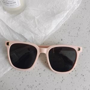 Gros plan de lunettes de soleil roses carrées pour enfants avec logo D doré
