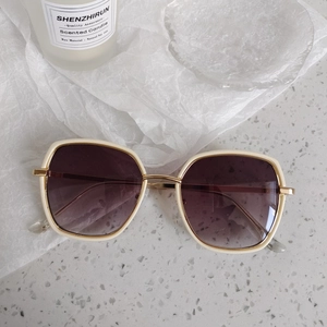 Détail de lunettes de soleil vintage ivoire à monture large avec verres dégradés violets