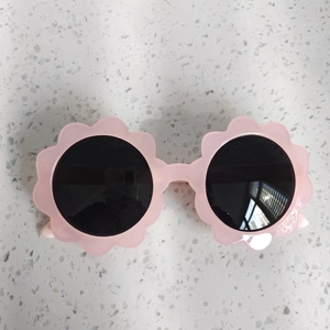 Dettaglio degli occhiali da sole a forma di fiore rosa chiaro per bambini con lenti scure
