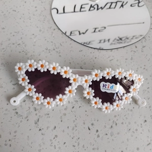 Dettaglio di occhiali da sole a margherita per bambini con lenti scure protettive UV400