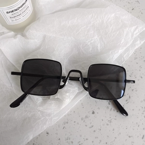 Détail de lunettes de soleil carrées noires pour enfants sur papier avec décor élégant