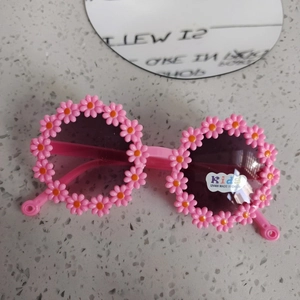 Dettaglio montatura a fiore rosa e lenti UV400 su occhiali da sole bimbi graziosi