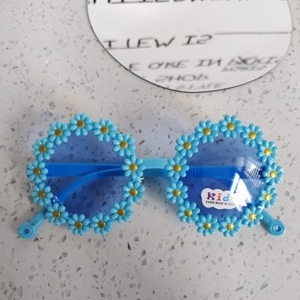 Dettaglio di occhiali da sole a fiore azzurri con protezione UV400 per bambini