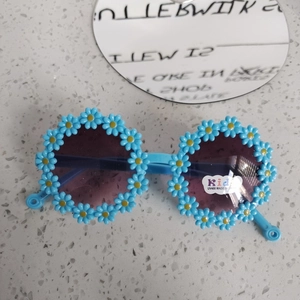Dettaglio degli occhiali da sole per bambini a forma di girasole blu con lenti UV400