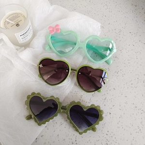 Three pairs of vintage heart-shaped sunglasses for kids in various shades of green