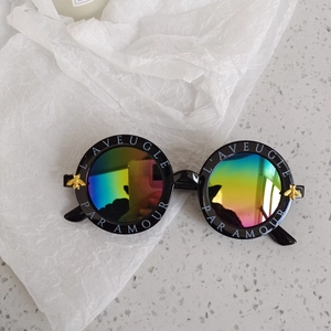 Detail of kids vintage sunglasses with gold bee emblem and L'AVEUGLE PAR AMOUR text