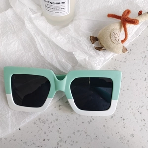 Detail of mint green and white color-block kids sunglasses with square black lenses