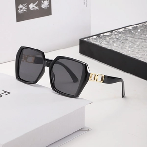 Fashionable oversized square black sunglasses with gold metal geometric details