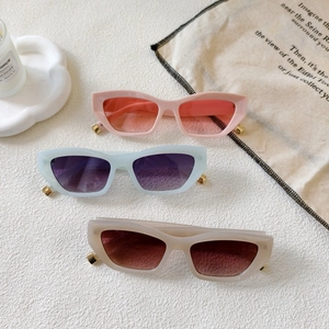 Retro cat-eye sunglasses in pink and beige with thick frames and gradient lenses