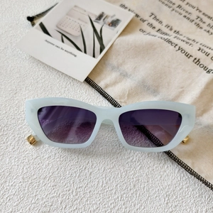 Detail of light blue cat eye sunglasses with gold hinge accents on stylish background