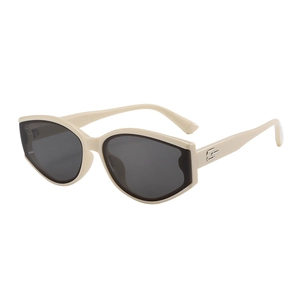 Détail de lunettes de soleil beiges avec verres gris et logo doré sur la branche