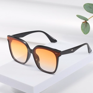Chic black square frame sunglasses with orange gradient lenses on white pedestal display