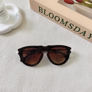 Detail shot of vintage square sunglasses with gradient lenses on a lifestyle backdrop