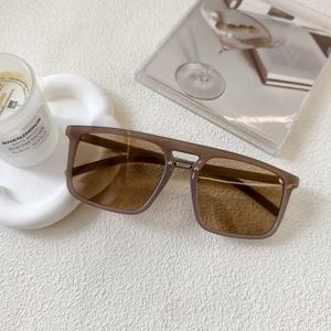 Close-up of square sunglasses with light brown transparent frames and dark brown lenses