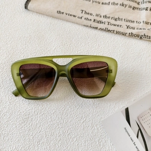 Macro view of olive green matte sunglasses with gradient lenses and镂空 bridge detail