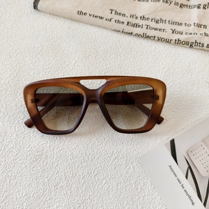 Detail of retro oversized sunglasses with double bridge and brown matte texture frame