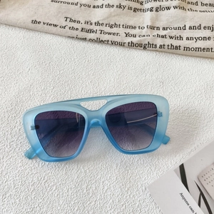 Detail of blue matte frame sunglasses with purple gradient lenses and hollow bridge design