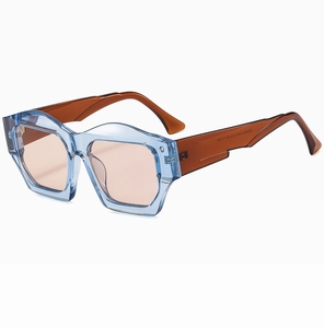 Detailed side view of irregular blue frame sunglasses with amber temples and pink lenses