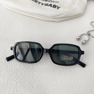Detail of black rectangular kids sunglasses with UV400 CE label on stone background