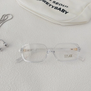 Detail of transparent square sunglasses with UV400 protection and gold hinge accents