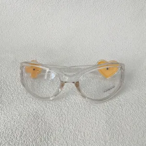 Détail de lunettes transparentes avec trèfle jaune et cœur, verres avec protection UV400
