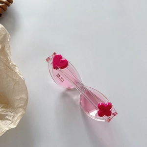 Détail des charms fleur et cœur sur lunettes de soleil roses pour enfants UV400
